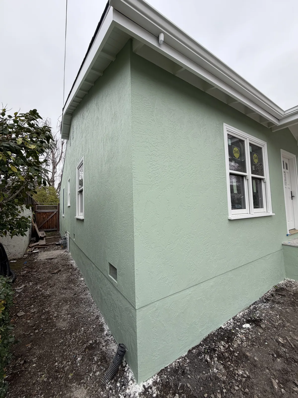 Finished sage green stucco exterior with clean corners and trim
